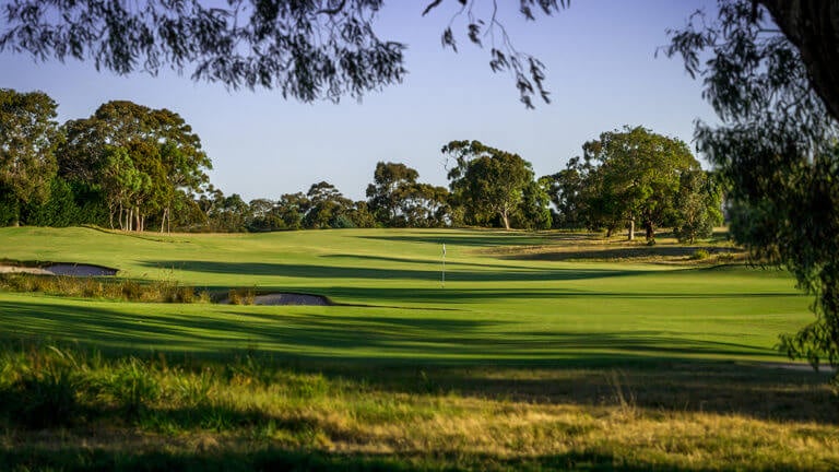 An open fairway leads downhill to a green at Melbourne's Victoria Golf Club