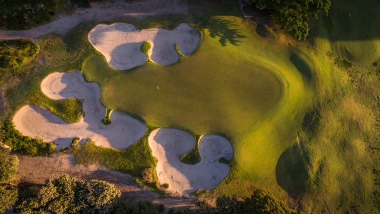 Birds-eye-view of large bunkers surrounding the tenth green at Kingston Heath Golf Club