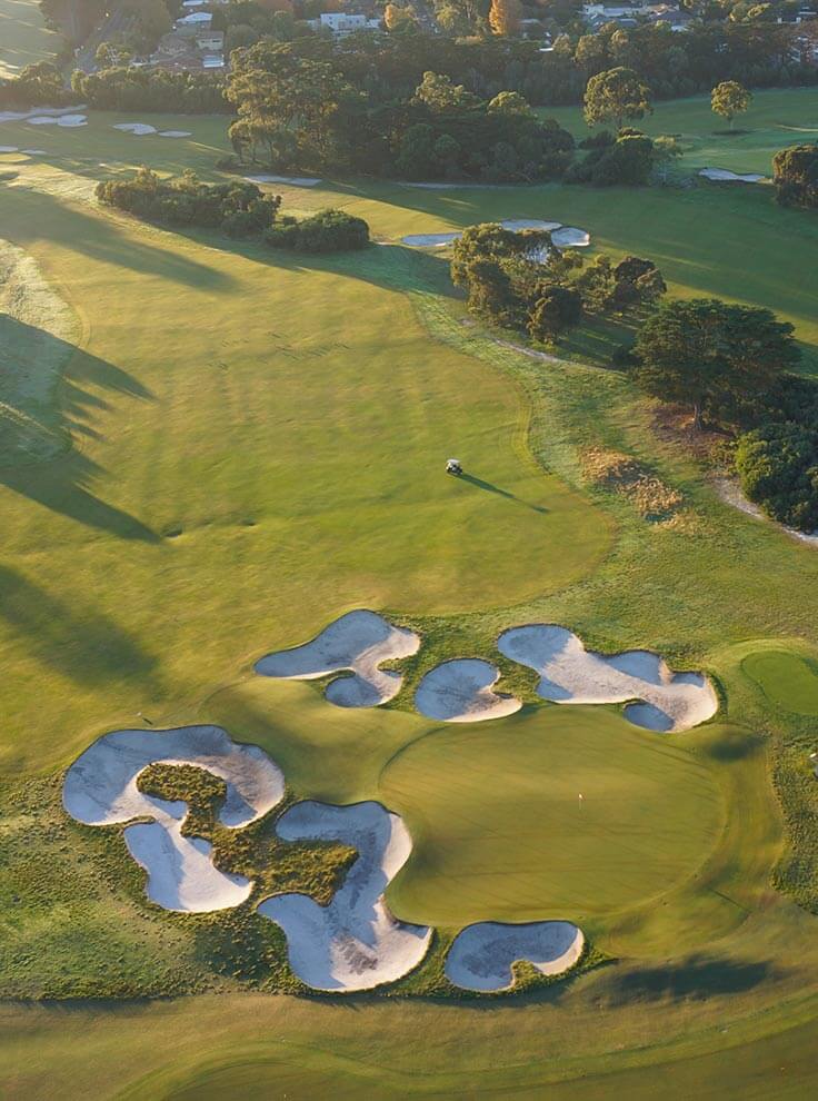 The setting sun casts a long shadow over the Royal Melbourne Golf Course
