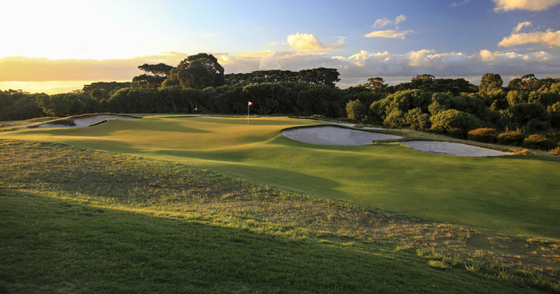 Setting sun casts golden light over the fifth green at Royal Melbourne