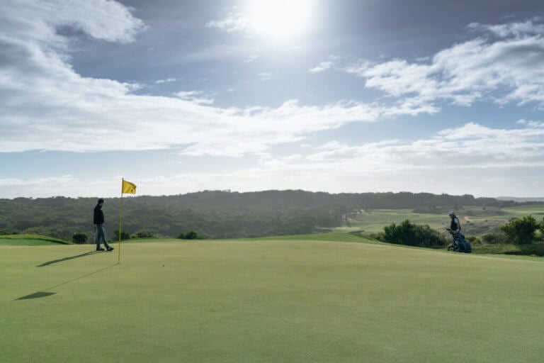 Golfers stand on the seventeenth green of the Gunnamatta Course