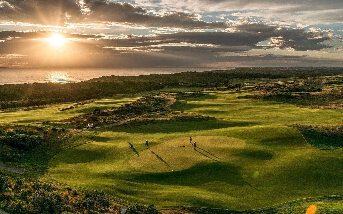 Golfers putt on the eighteenth green of the Gunnamatta Course at sunset