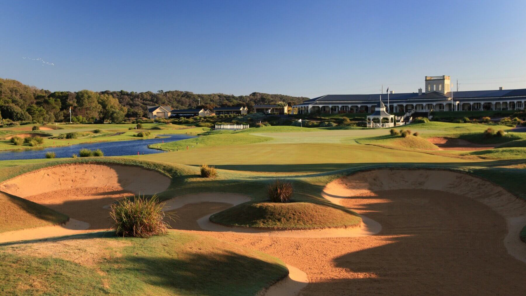 Large bunker leads to the eighteenth green and distant clubhouse in view at the Eagle Ridge Golf Club