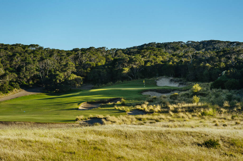 A raised green is protected by bunkers and foliage at St Andrews Beach Golf Club