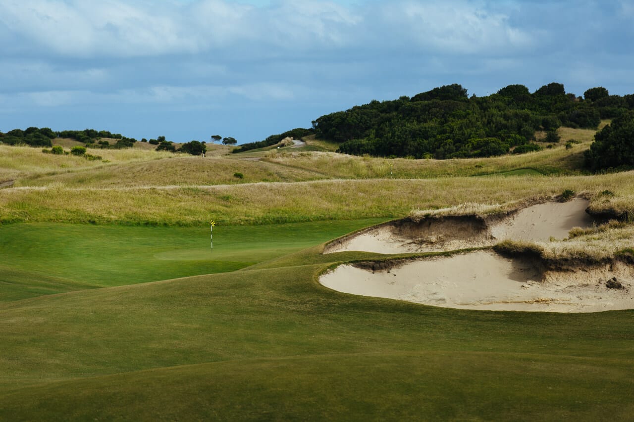 Large sand bunkers protect three sides of a green at St Andrews Beach Golf Club