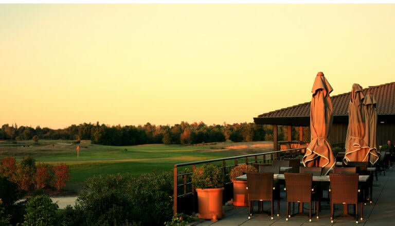 Outdoor patio overlooks the golf course at Du Medoc Resort