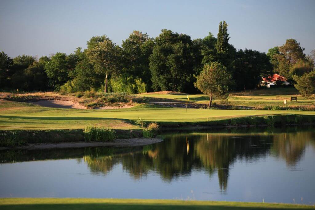 A lake sits adjacent to the golf course at Golf du Medoc Resort in France