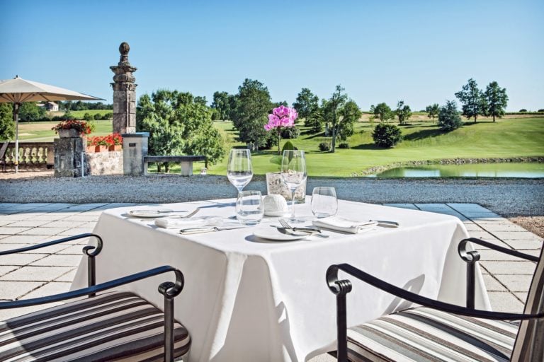 Outdoor dining on a terrace overlooks the golf course and stunning scenery