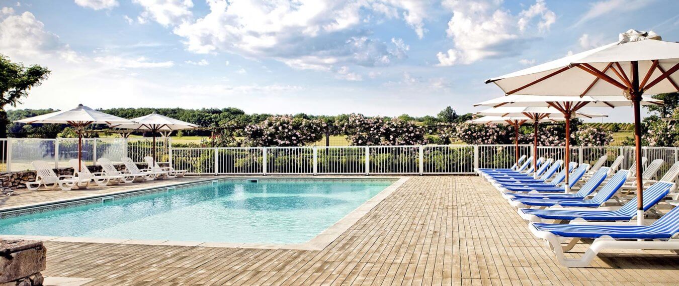Outdoor pool is flanked by sun lounges at Chateaux des Vigiers Resort