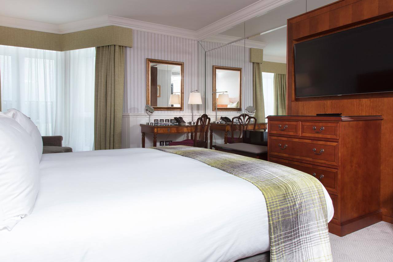 Well-appointed bedroom with king bed and separate work desk