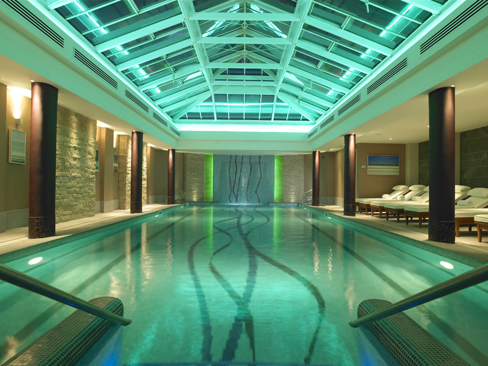 Internal view of the leisure pool with blue lighting and lounge chairs