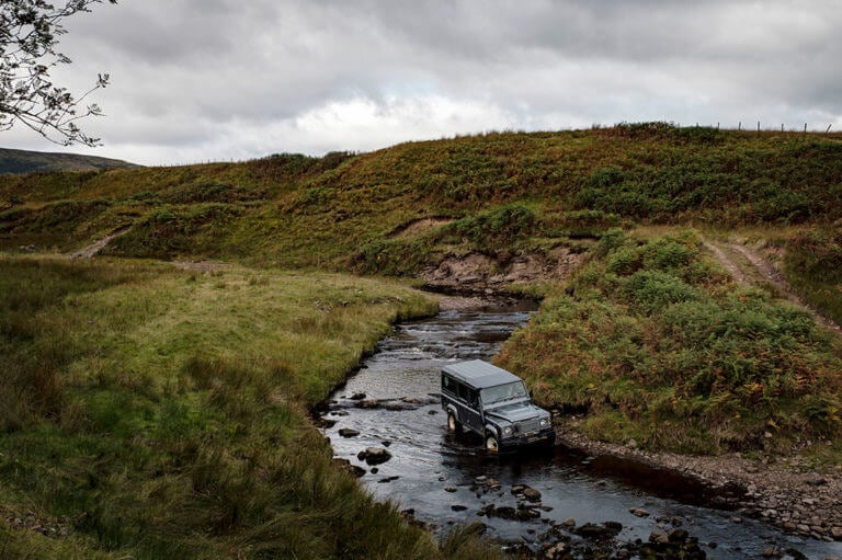 A Landrover drives through a river on the Gleneagles property