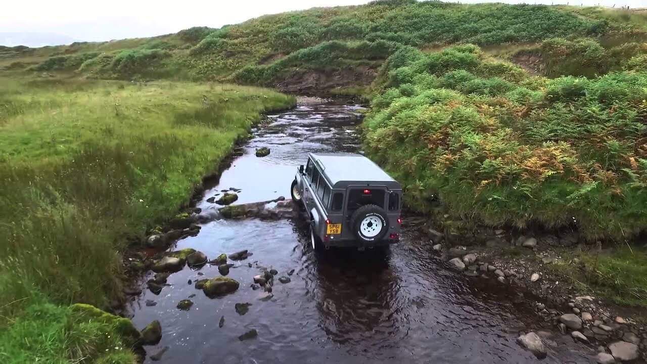 A landrover drives up a river at Gleneagles Resort