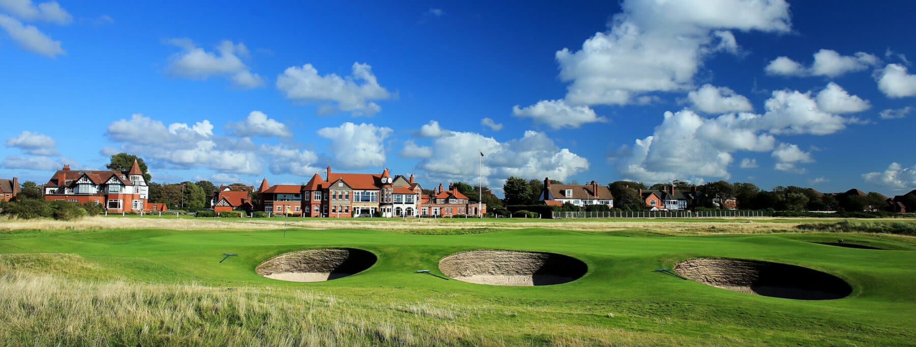 Landscape view of the Royal Liverpool clubhouse and nearby pot bunkers