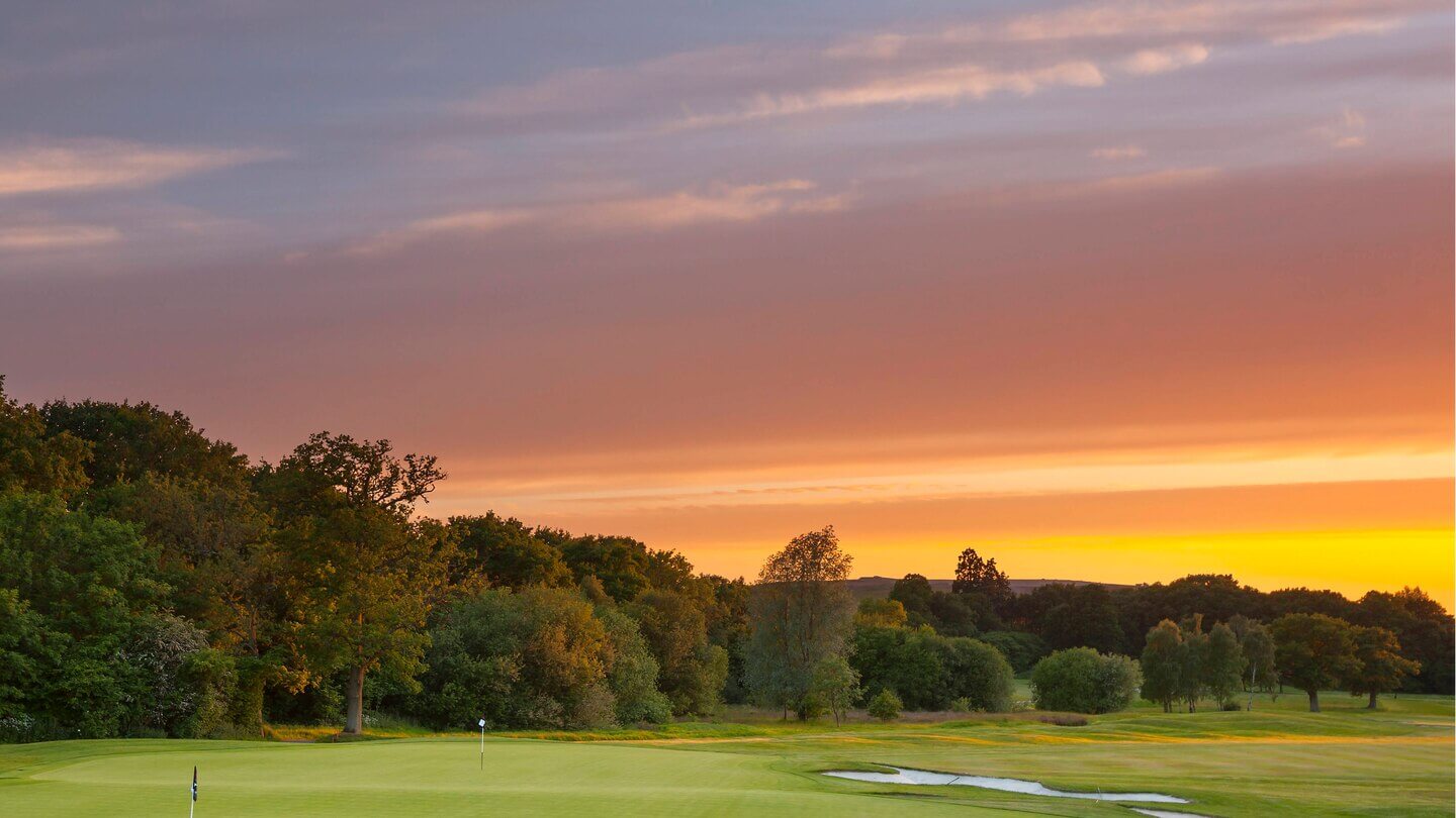 Setting sun casts golden light over the golf course and countryside