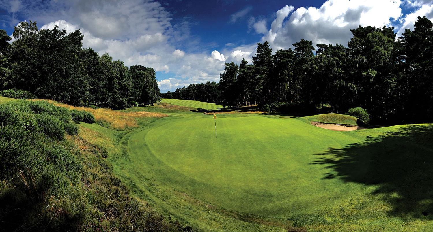 A narrow plateaued green caught between a downhill bunker and hill