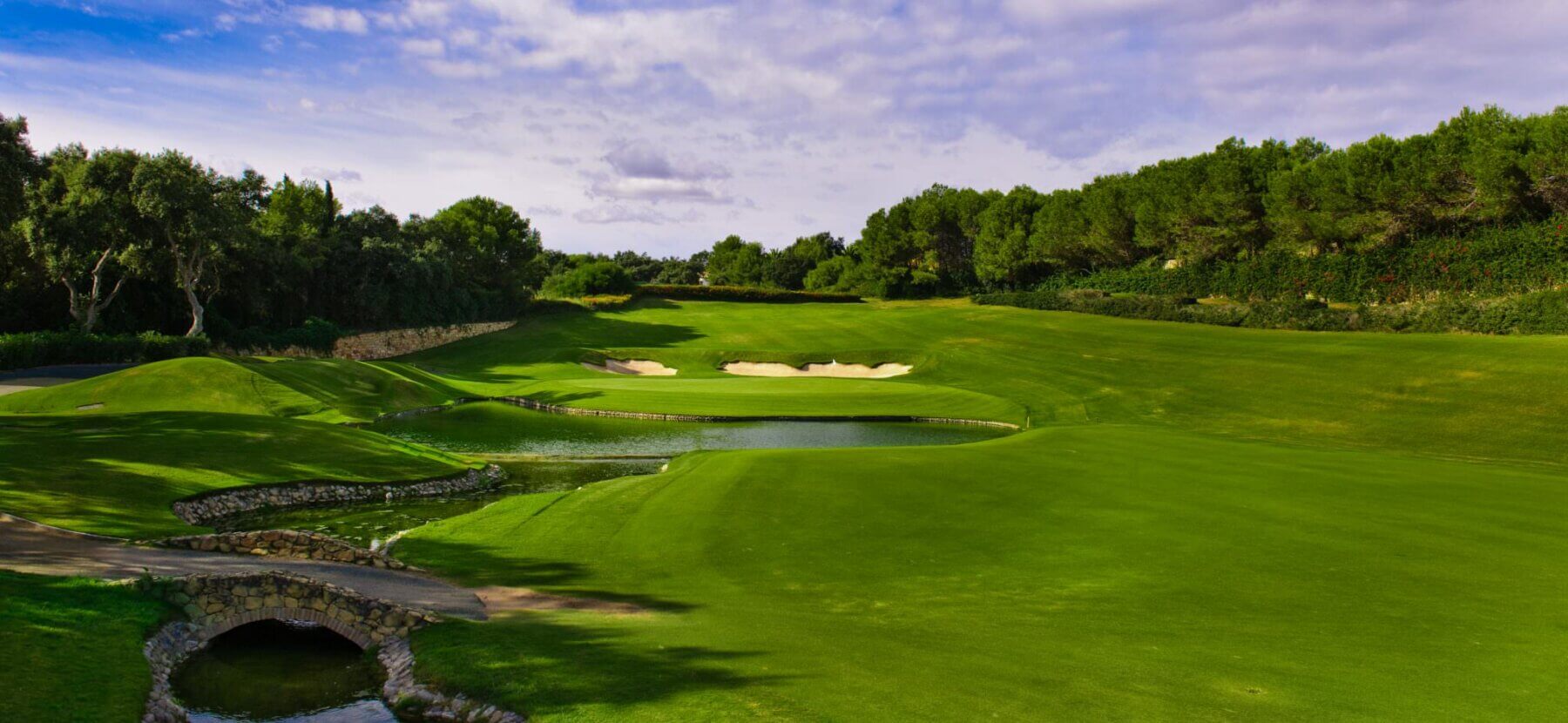 A lake descends from an uphill green at Real Club Valderrama Golf Club