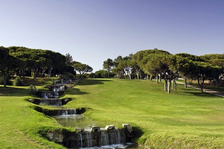 A tiered waterfall runs adjacent to the Ocean Course at Vale do Lobo