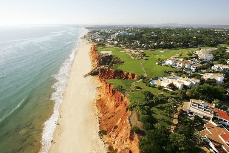 Aerial view of red-sand cliffs separating the Atlantic sea from the Vale do Lobo golf complex