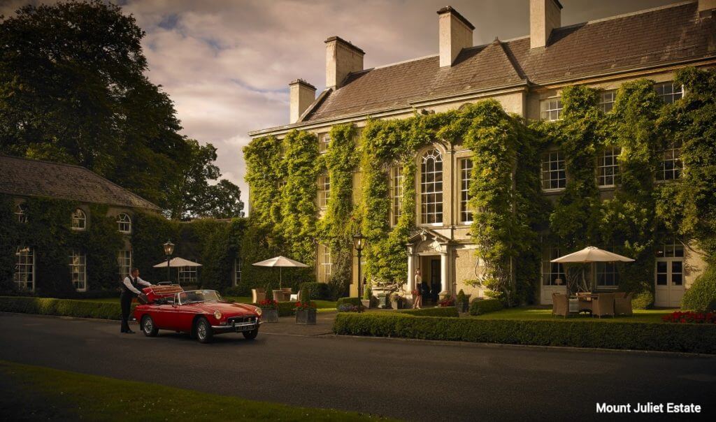 A vintage car parked outside the main resort building