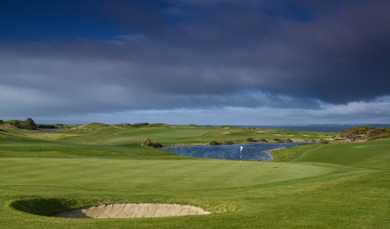 The 11th green overlooks a golf course lake