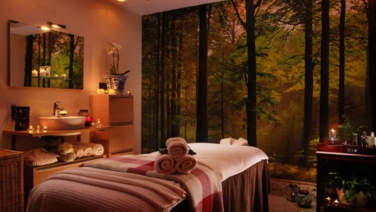 A spa treatment room with forest wallpaper