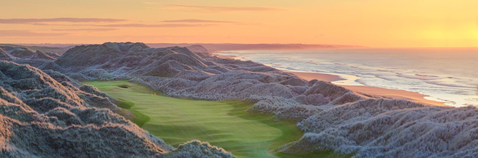 Golden sunlight shines over the Trump International dunes