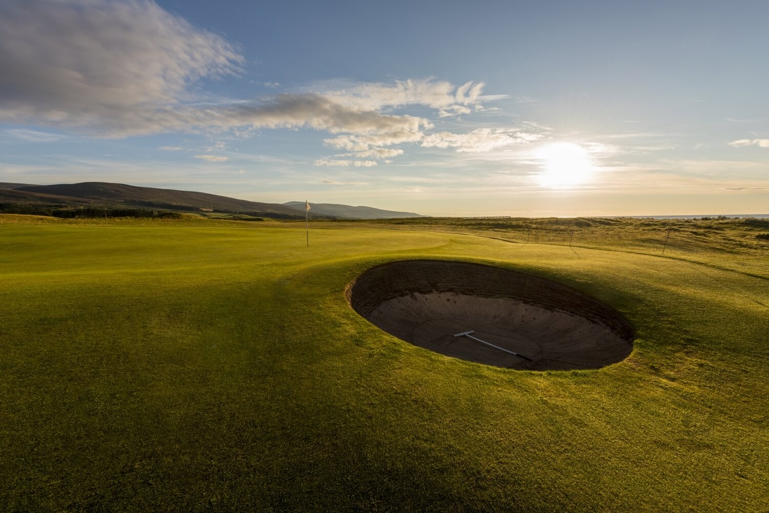 A round pot-bunker protects a green at Brora Golf Club