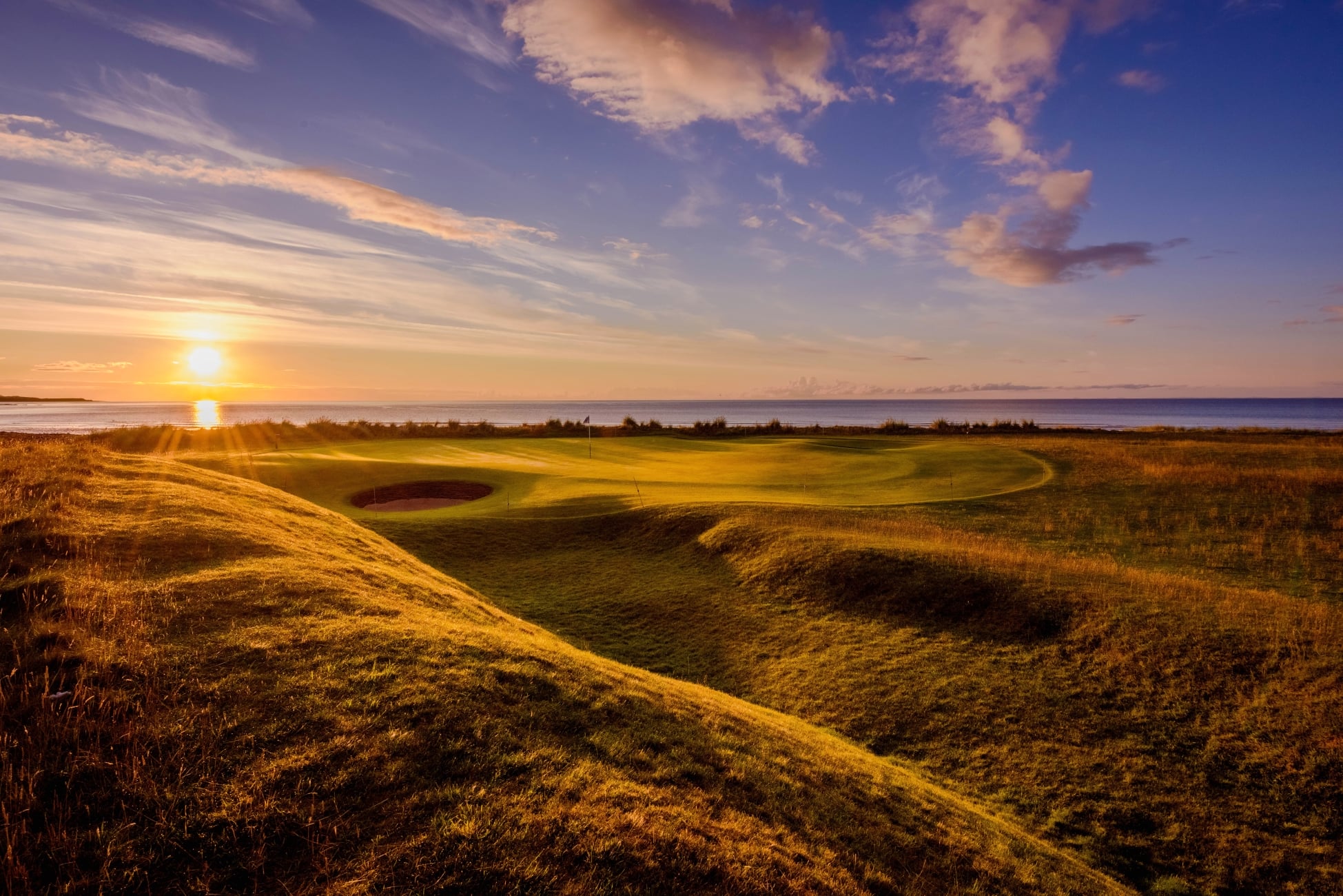 Golden light of sunset shines over the Brora Golf Club in Scotland