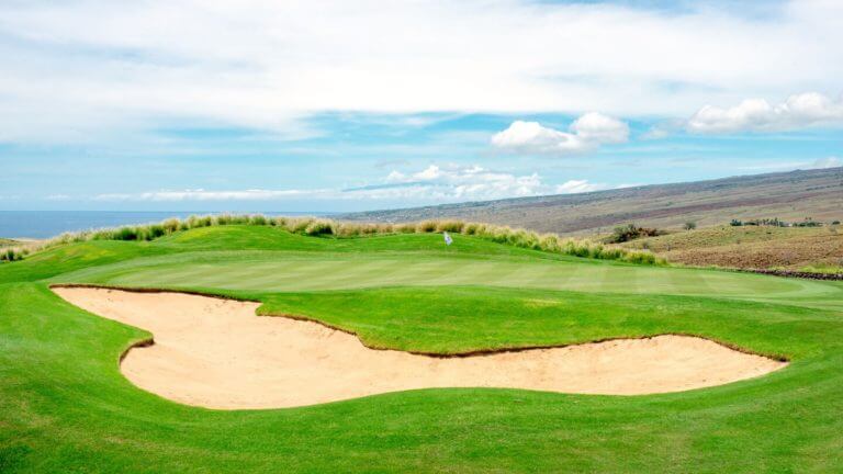 A large bunker protects a raised golf green at Westin Hapuna Beach Resort