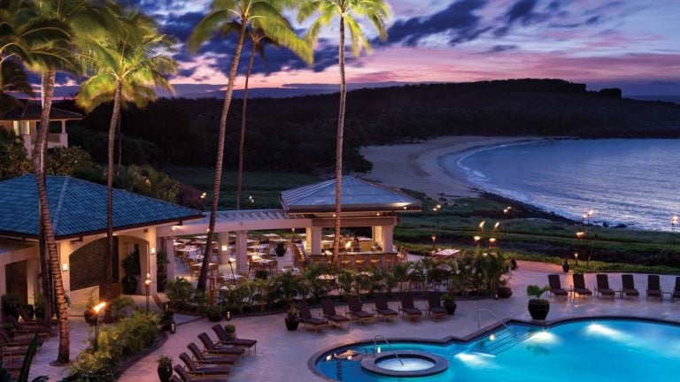 Purple skies shine over a patio dining area at Four Seasons Resort in Lanai