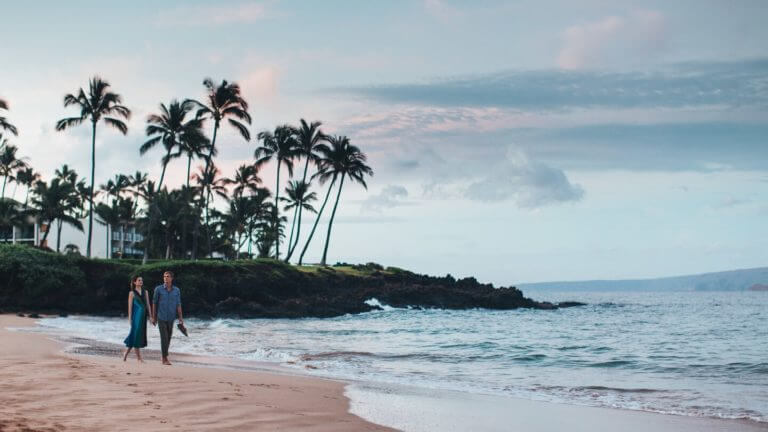 A couple walks on the private beach in front of Wailea Beach Resort
