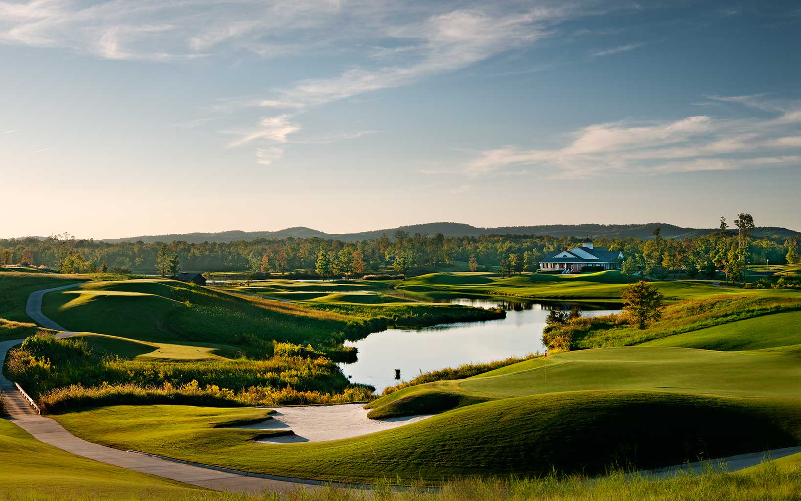 Golden light of dusk shines over the ninth hole of the Heartbreaker golf course