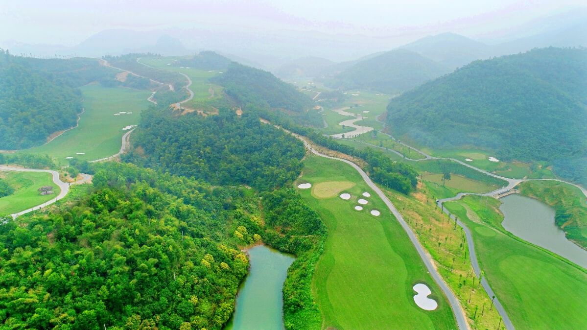 Aerial view of golf holes winding through a valley