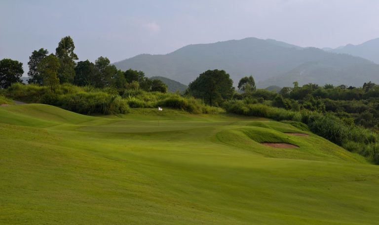 Large mountains loom behind the seventeenth hole