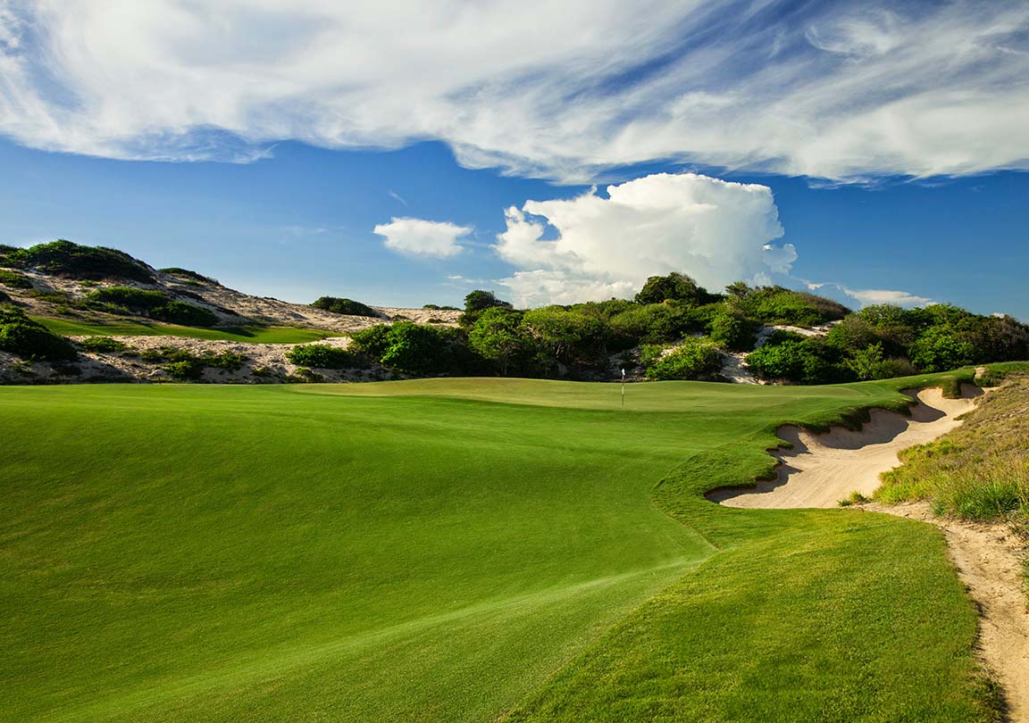 Large sand bunker runs along a golf hole