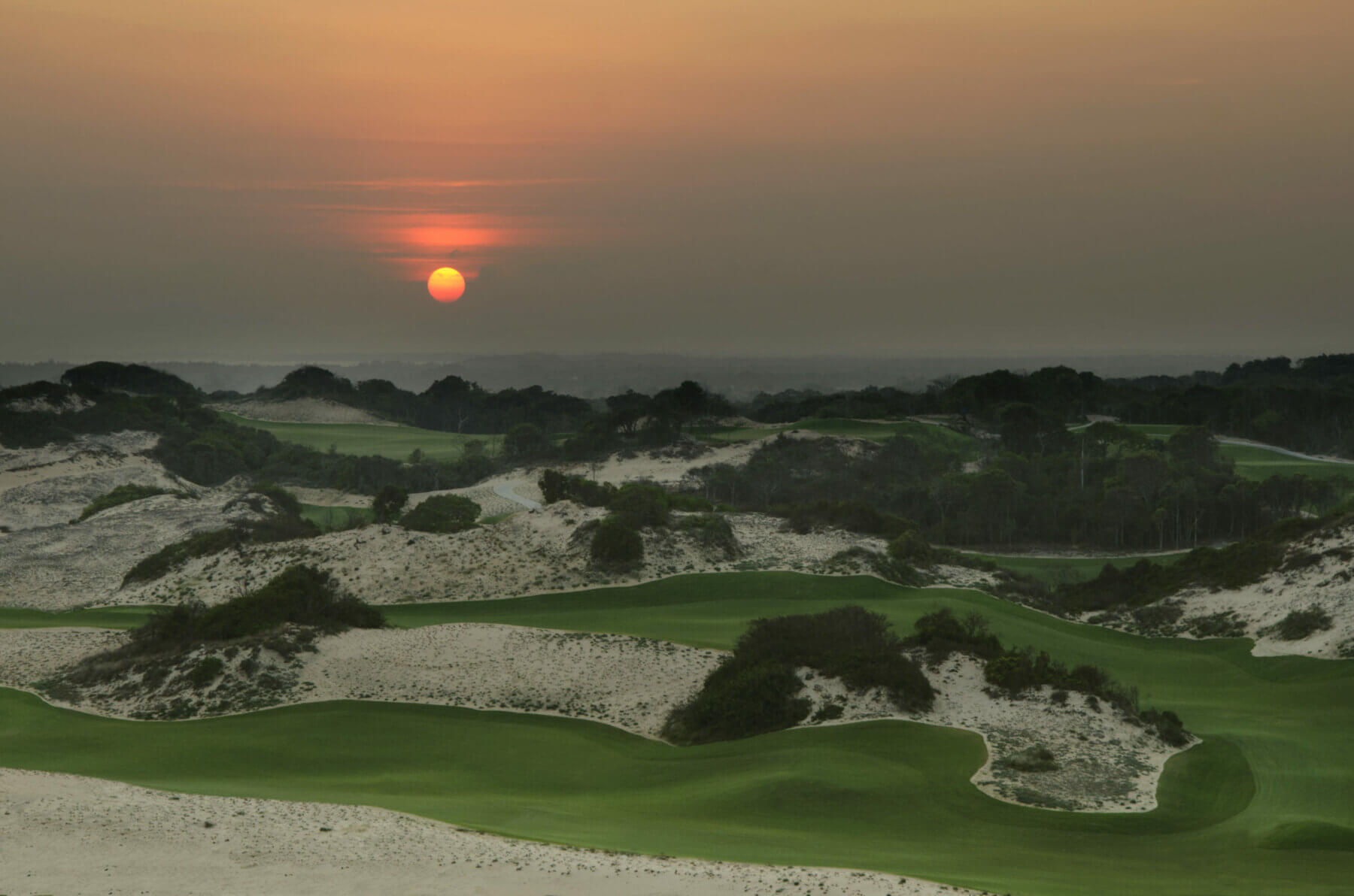 Red sun settles over the golf course