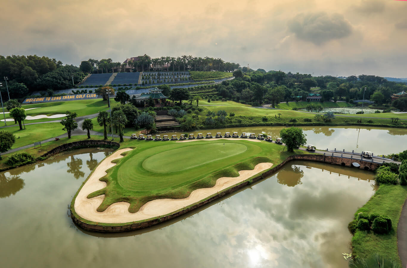 A large green is manicured around a bunker and lake at Long Thanh