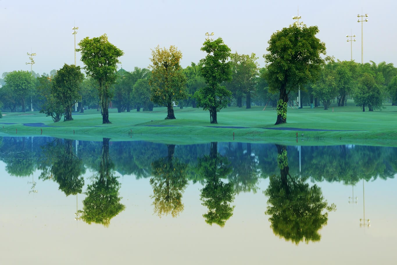 Trees stand on the side of a lake at Long Thanh Golf Club