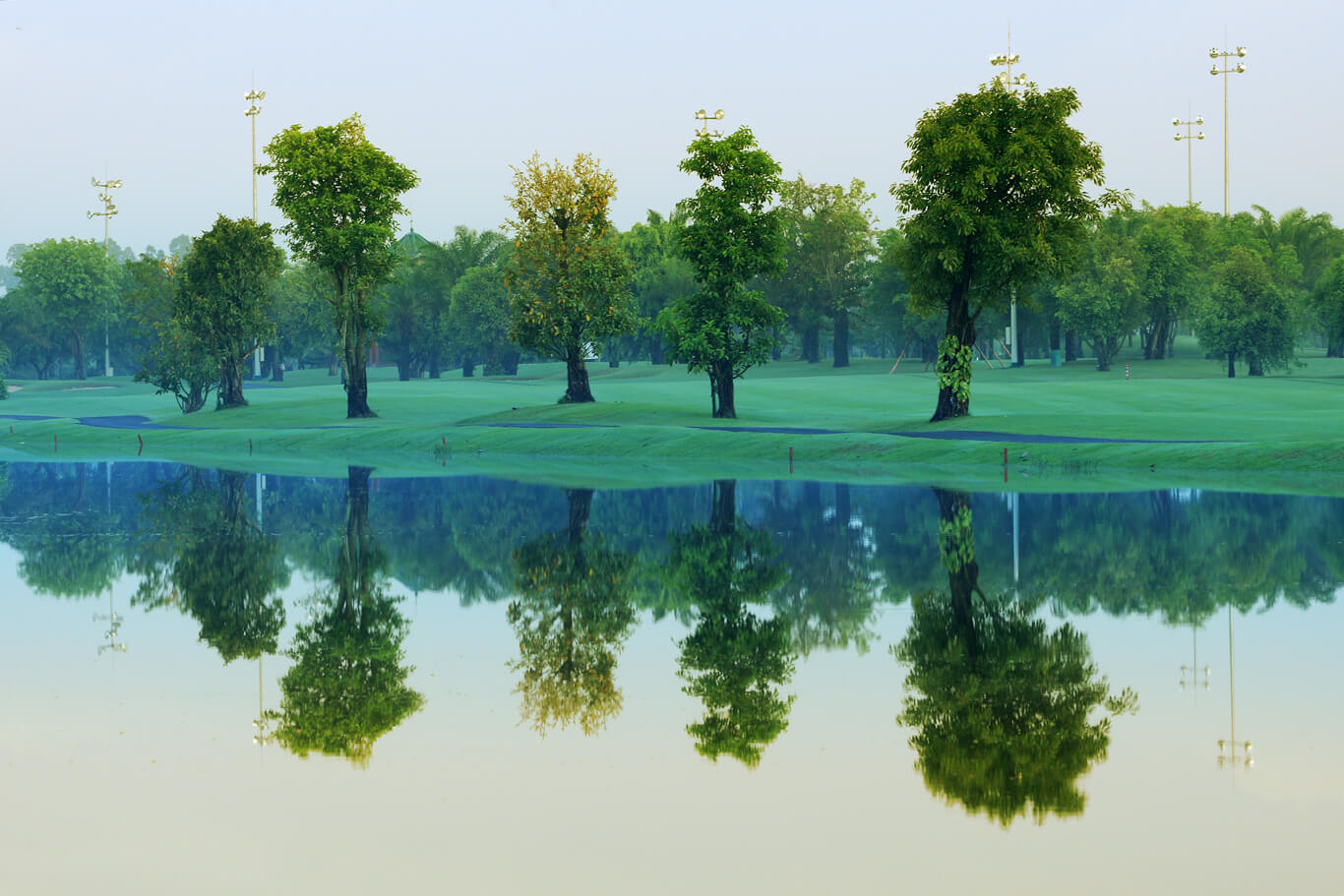 Trees stand on the side of a lake at Long Thanh Golf Club