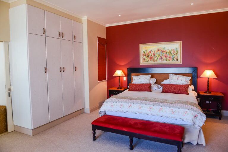 Red-painted room and double bed in Pinnacle Point accommodation