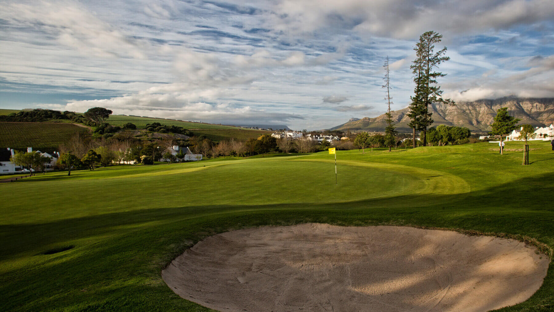 A yellow flag stands in the green next to the bunker