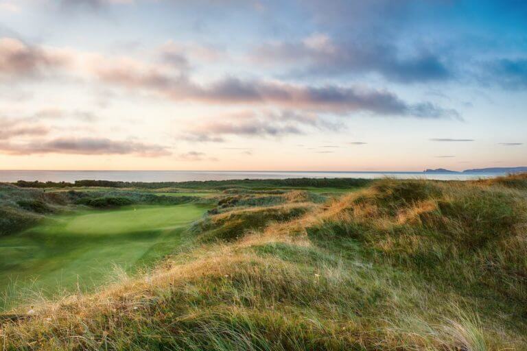 Morning sun rises over the first hole of The Island Golf Club in Ireland