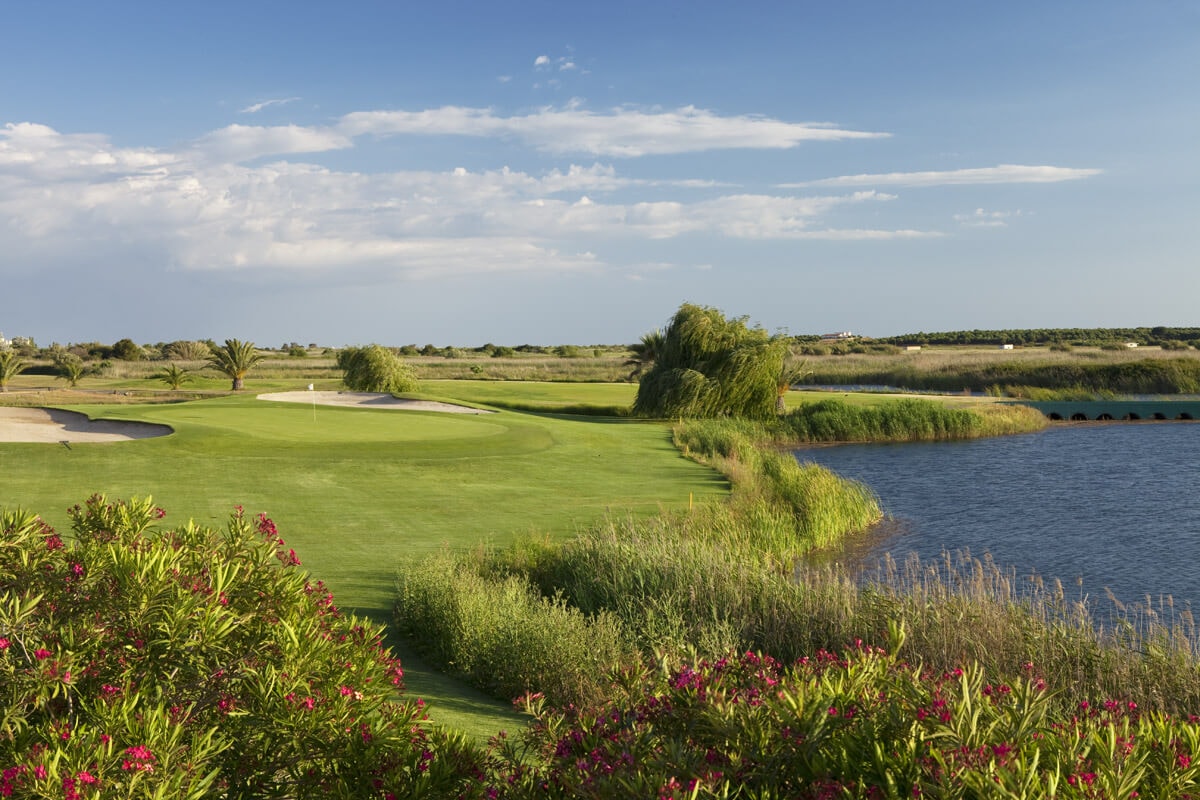 Lush fairway and green protected on one side by large lake
