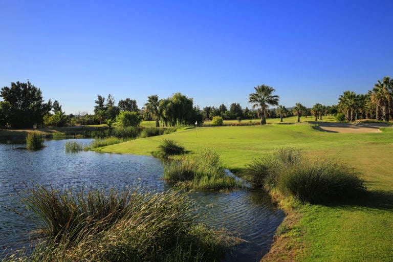 Lush golf course stands next to lake at Dom Pedro Golf