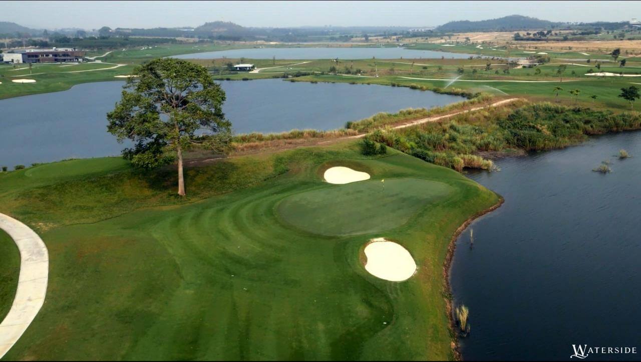 Green stands next to a lake on the Waterside course at Siam Country Club