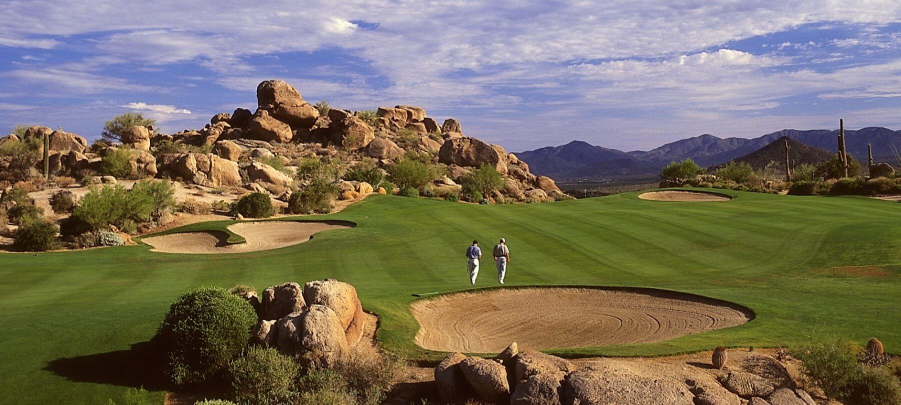 Two golfers walk The Monument Golf Course