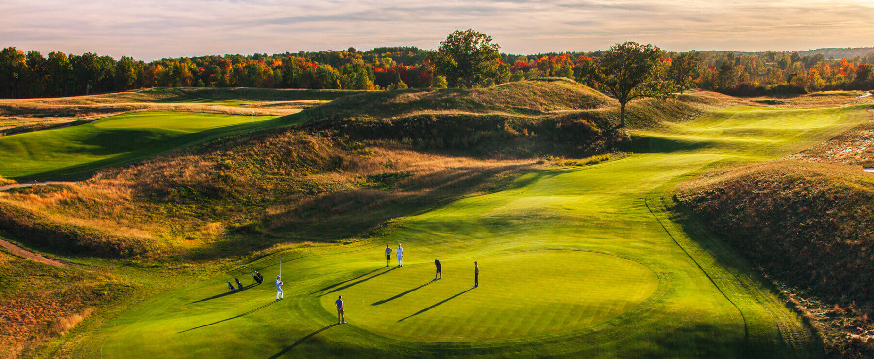 Golfers putt on a green at Erin Hills golf course